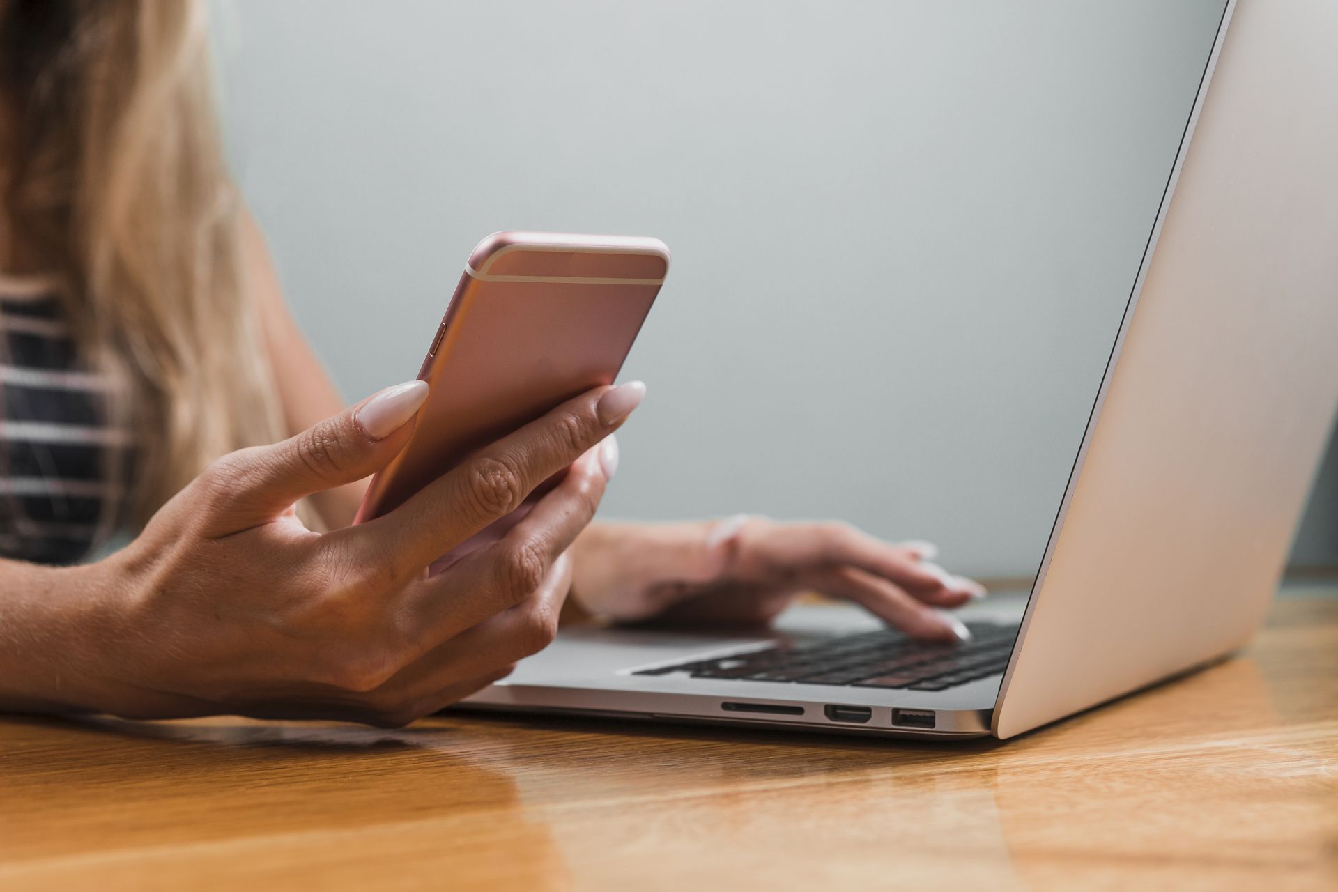 woman-hands-using-phone-laptop